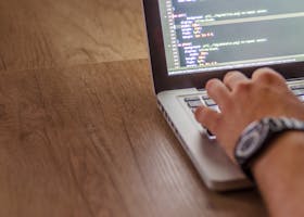 Close-up of a person coding on a laptop, showcasing web development and programming concepts.
